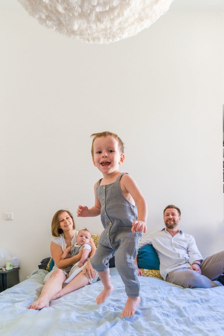 Portrait de famille à bordeaux - enfant saut sur le lit