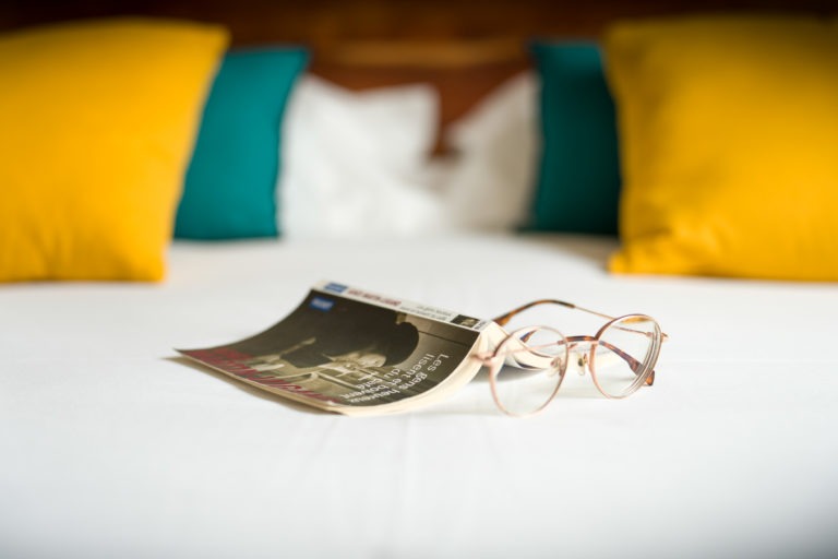 Immobilier - Appart'hotel - livre et lunette sur un lit