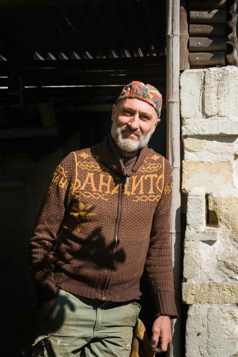 Philippe Sanchez, artisan coutelier debout sur seuil de la porte de son atelier
