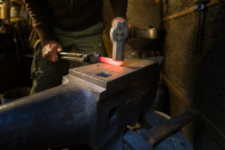 Un artisan coutelier forge une lame chauffée à blanc