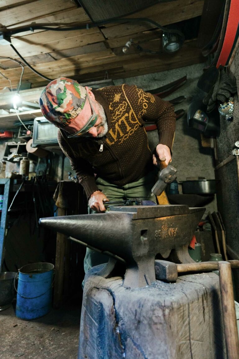 Un artisan coutelier utilise un marteau et une enclume