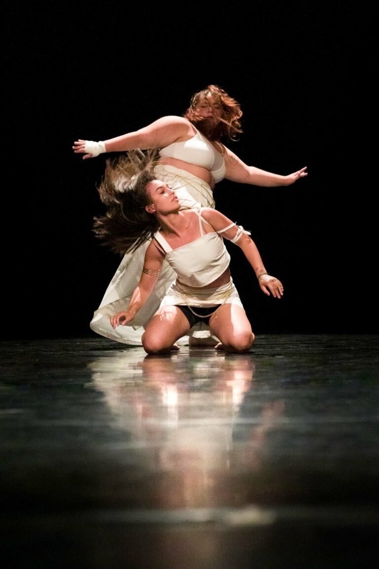 De danseuses faisant une prestation sur scène ou l'une sur les genoux l'autre debout